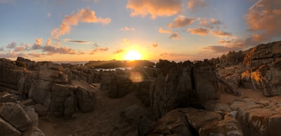 橘色的夕阳躲在棕色的山峰后面